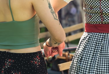 Hände halten Eheringe an einer Schnur hinter dem Rücken. Kreatives Hochzeitsdetail von Joel Pingel.