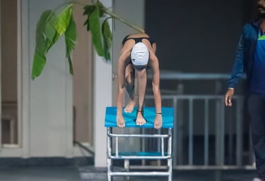 “Instructor assisting a swimmer preparing to dive into the pool for rehabilitation exercises.”