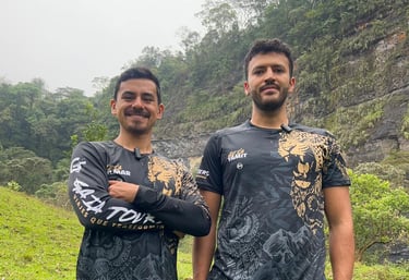 Dos hombres con camisetas de senderismo gráficas a juego de Gaia Tour posando al aire libre 