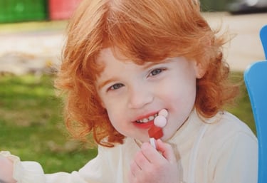 a young girl with red hair and a white shirt