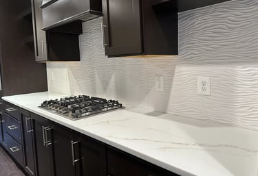 Textured white wave backsplash tile installed behind gas cooktop and quartz.