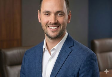 Professional headshot of a smiling male executive in a blue blazer and white shirt in an office setting.