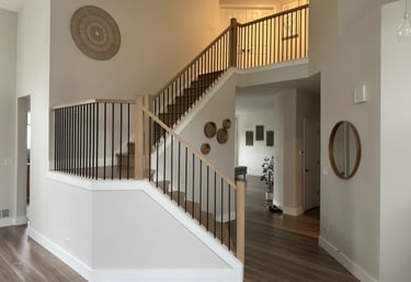 Custom oak staircase renovation with modern black iron railings in a Lake in the Hills home