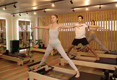 Three people practicing Pilates Warrior II pose on reformers in a modern studio.