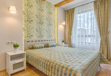 Modänes Hotelzimmer mit schickem Interieur einem Bett, Beistelltisch und hellen Vorhängen