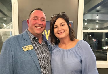 a man and woman standing in front of a window