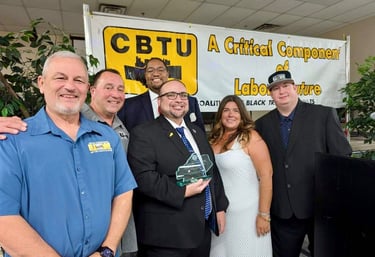 a group of people standing around a man in a suit and tie