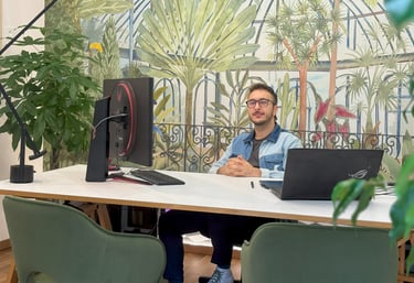 the owner sitting at the desk of the studio with his computer