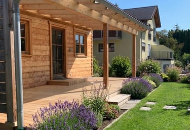 Überdachte Holzterrasse an einer Holzfassade im Garten von Holztechnik Volk am Ammersee