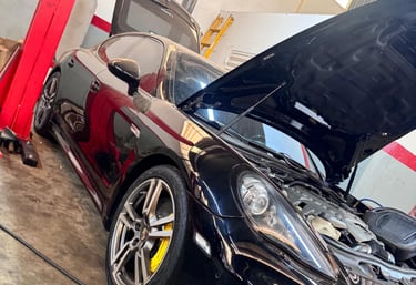 Um carro com o capô aberto, pronto receber a troca da sua bateria em uma loja de baterias de carro.