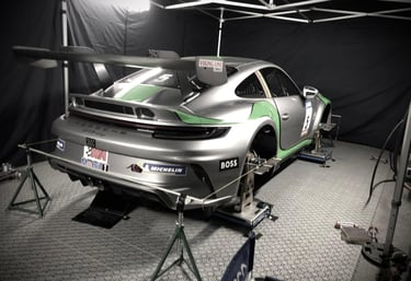 an Enlab Porsche car is parked in a garage with a car in the background