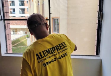 a man in a yellow shirt is looking out the window