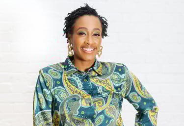 a woman in a blue paisley shirt and tan pants