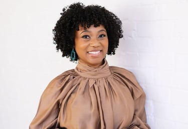 a woman in a brown blouse and green pants