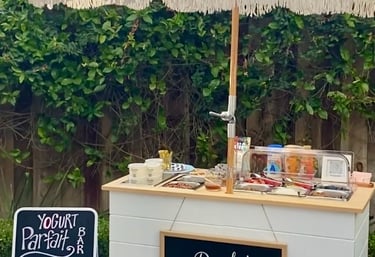 Yogurt parfait bar cart with umbrella at a party
