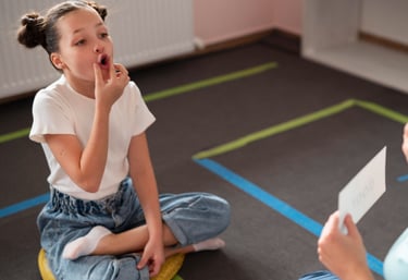 Een jong meisje dat al zittend mondoefeningen aan het uitvoeren is