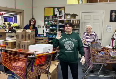 A group of happy volunteers working in the food pantry