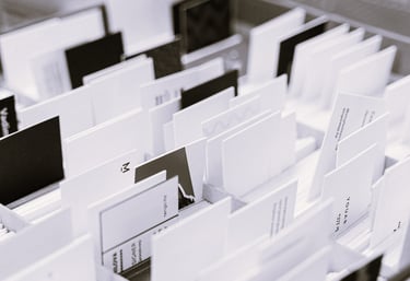 Photo en noir et blanc de plusieurs cartes de visite et supports triés