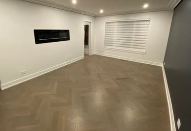 Custom herringbone hardwood flooring installation with modern fireplace in a Chicago North Shore home