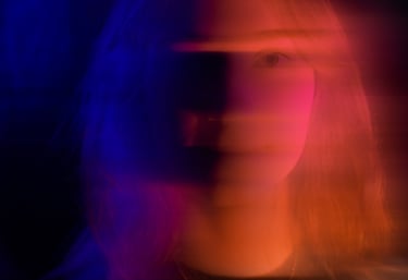 portrait d'une vidéaste avec des jeux de lumière rose et bleu