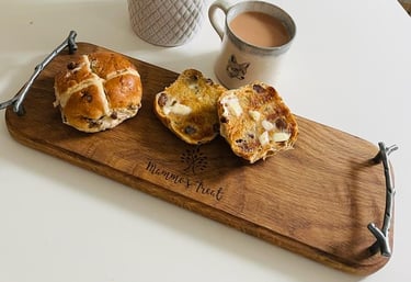 a wooden serving board with hot cross buns and a cup of tea