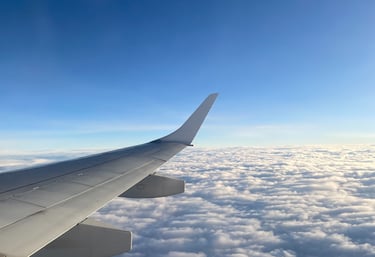 a view of a wing of a plane above the clouds