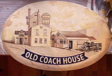 Close-up of pub sign with painted brewery building