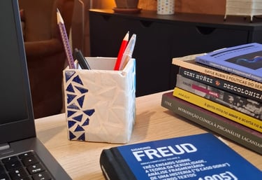 Mesa de trabalho com livros de autoras como Ana Suy, Gayle Rubin e Geni Núñez, ao lado do notebook u