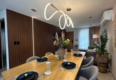 a dining room table with a wooden table and chairs and modern lighting