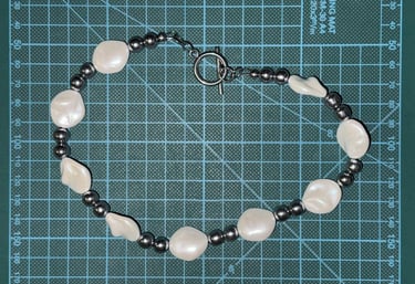 Unisex necklace with irregular pearl masses and polished hematite beads, styled with a toggle clasp