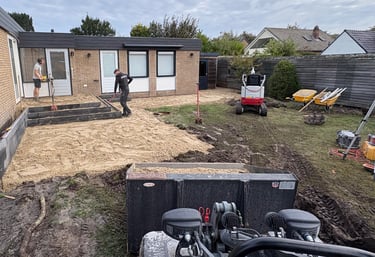 Betsema Bestrating bezig met grondwerk in een tuin.