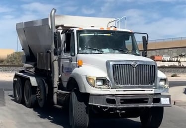 a dump truck with a cement mixer in the back ground
