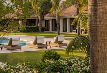 Sun loungers and palm garden by the pool at Villa El Olivo, Marbella Golf Valley.