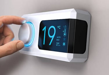 main qui règle un thermostat d'ambiance blanc et noir sur 19 degrès