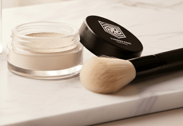 a table with a brush and a bottle of liquid foundation