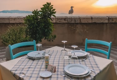 Dinner table on Cagliari bastions at sunset with seagull in background