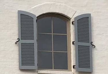 fixed louver shutters with decorative hardware to open and close and protect