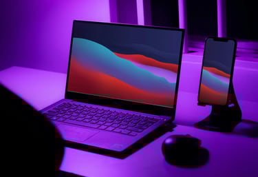a laptop computer sitting on a desk with a purple light