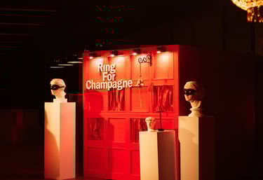Prabangiai apšviesta „Ring for Champagne“ šampano sienelė su skambučiu elegantiškoje erdvėje