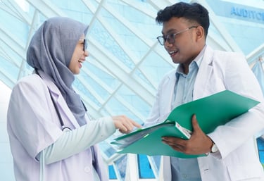 Dua tenaga medis mendiskusikan uji klinis dalam proses pengembangan protokol penelitian