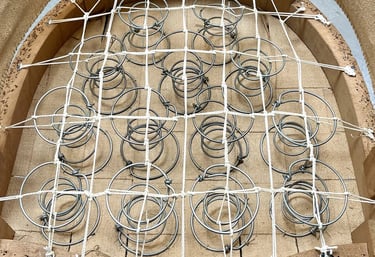 Carcasse d'un fauteuil crapaud avec sur le sanglage des ressorts guindés par des cordes