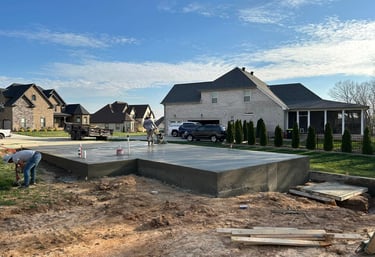 a man is working on a concrete slab in a residential area