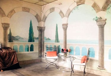 Interior mural with Moorish arches, terrace, cypress trees and ocean view.