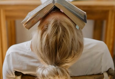 photo d'une jeune fille, un livre sur la tête, déconcentrée