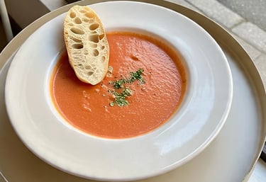 a bowl of soup with breaded bread on a table