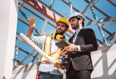 Dois profissionais de Engenharia e Regularização de Obras analisando uma construção civil