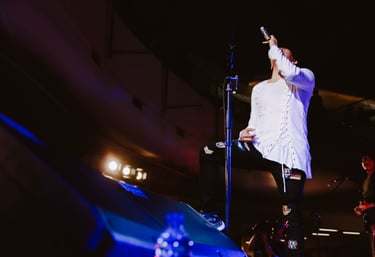 a singer in a white shirt and black pants