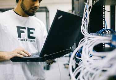 a man in a white shirt is holding a laptop computer
