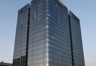 Modern architectural shot of a sleek glass business center in Almaty during twilight, symbolizing corporate stability and innovation in Kazakhstan.