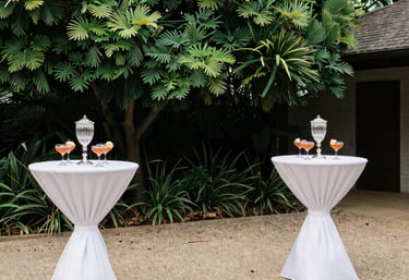 A neatly arranged outdoor event setup with elegant tables and chairs.